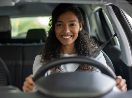 a woman smiling sitting in her new car