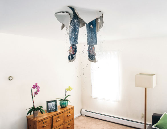 a person's feet coming from a room ceiling.