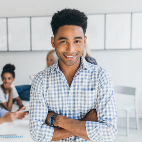 black male with arms crossed smiling